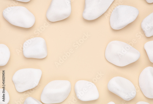 White pebbles on beige background. Copy space