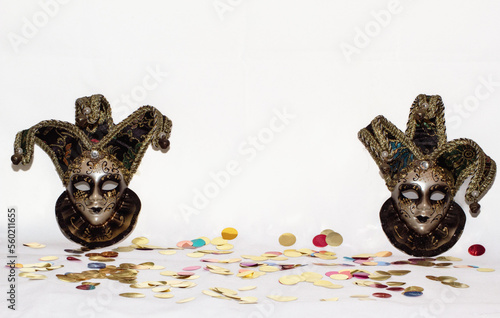 Pareja de máscaras venecianas sobre un fondo blanco con temática de Carnavales con confeti de colores por todos lados. photo