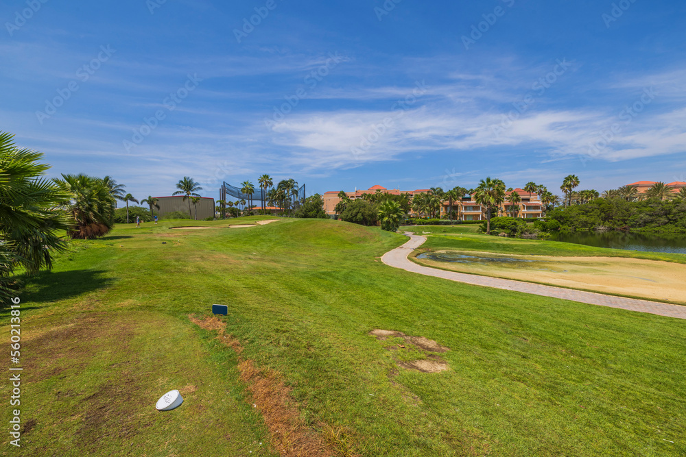 Beautiful landscape view of golf course with green grass in background of hotel with lake. Aruba. Beautiful landscape view of golf course with green grass in background of hotel with lake. Aruba.