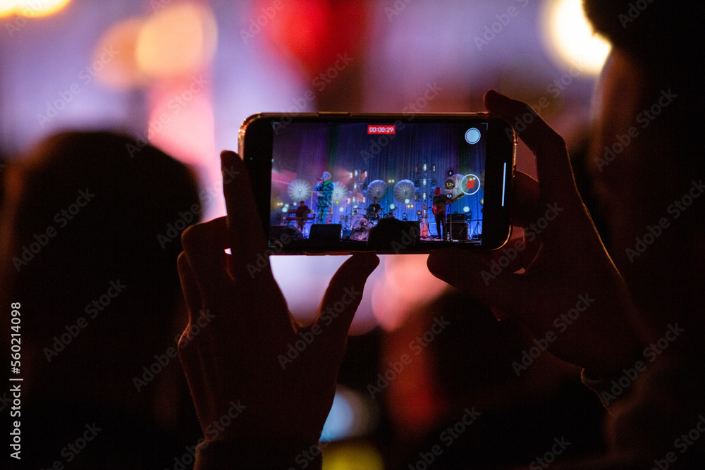 Kobieta nagrywająca koncert telefonem komórkowym. Nagrywanie koncertu telefonem. Kobieta nagrywająca koncert telefonem komórkowym. Nagrywanie koncertu telefonem.