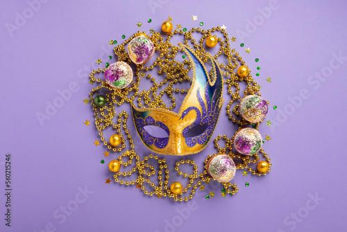 Fototapeta Naklejka Na Ścianę i Meble -  Mardi Gras King Cake Muffins or Cupcakes, Carnival Masks on Purple Background.