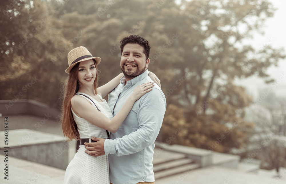 International loving couple hugging and looking at the camera in the city International loving couple hugging and looking at the camera in the city