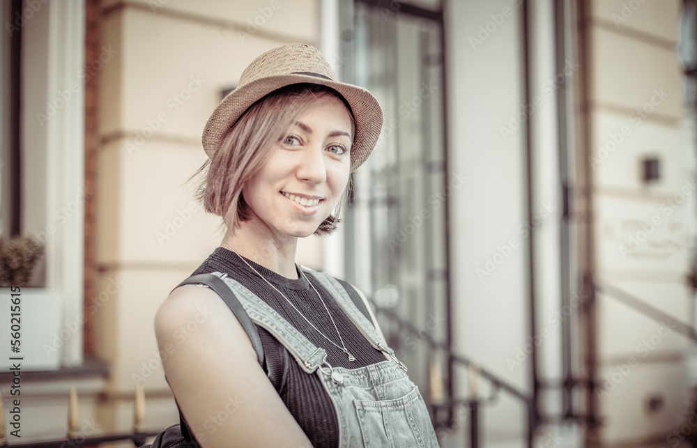Fototapeta premium Portrait of a young stylish Caucasian woman in hat in city