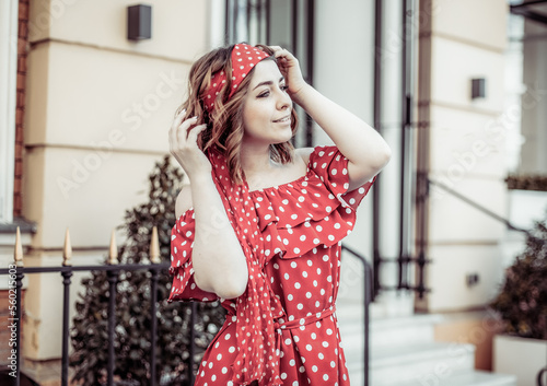 Portrait of young beautiful woman in red dress with polka dots outdoors
