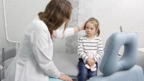 Sad little girl with a toy in the office of a child psychologist.