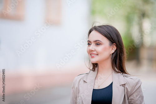 Free Download Young beautiful woman 19 years old in stylish clothes. Model with dark hair in casual clothes walks through the spring blooming city. Warm. - GFXLoad
