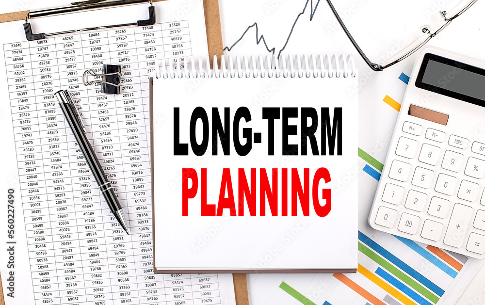 LONG TERM PLANNING text on notebook with chart, calculator and pen LONG TERM PLANNING text on notebook with chart, calculator and pen