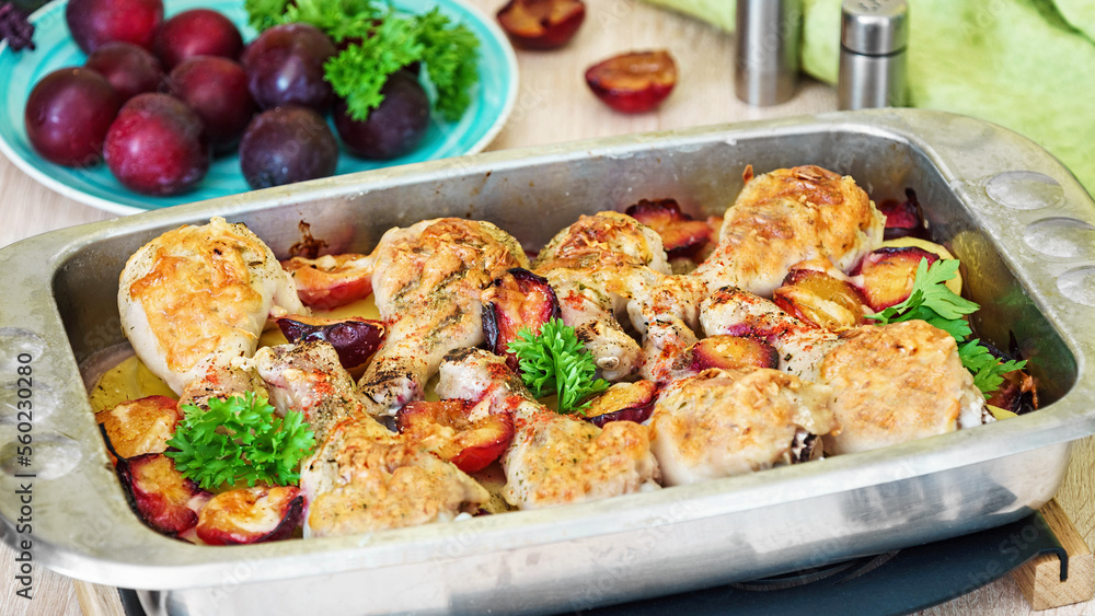 Chicken legs baked in cheese with plums and potatoes