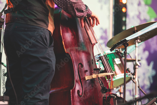 Concert view of contrabass violoncello player with musical band during jazz orchestra band performing music, violoncellist contrabassist cello jazz player on stage