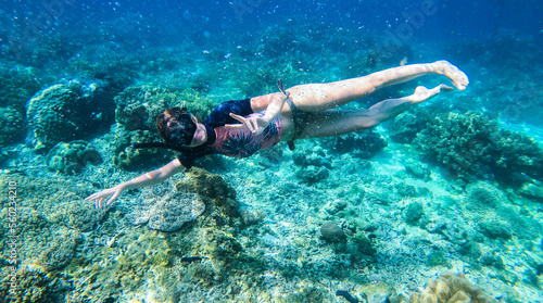 Happy woman with snorkeling mask and dive underwater in coral reef. Travel activity and water sports