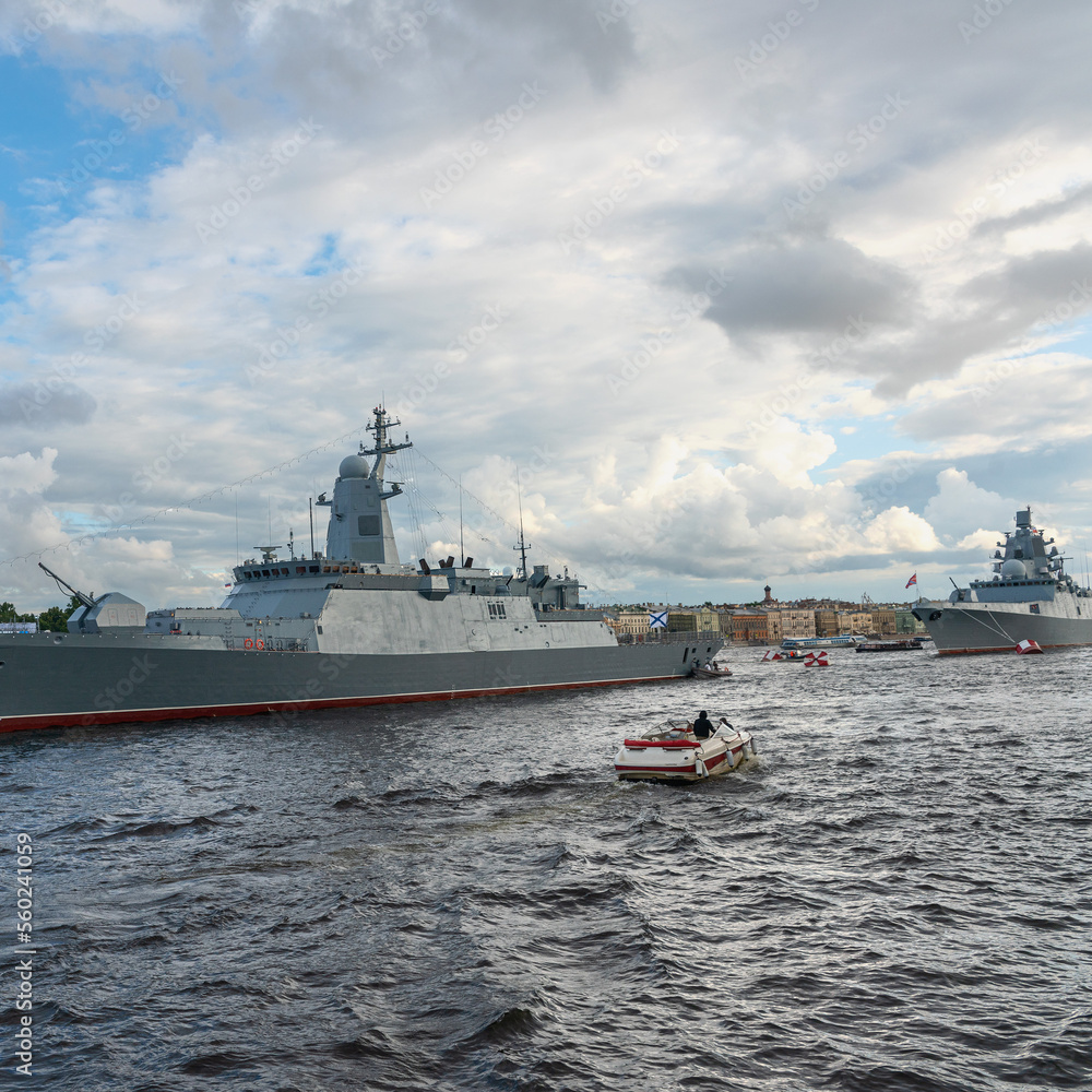 tourists on a pleasure boat take pictures of a warship parked on the river in the center of the city of St. Petersburg, Russia tourists on a pleasure boat take pictures of a warship parked on the river in the center of the city of St. Petersburg, Russia