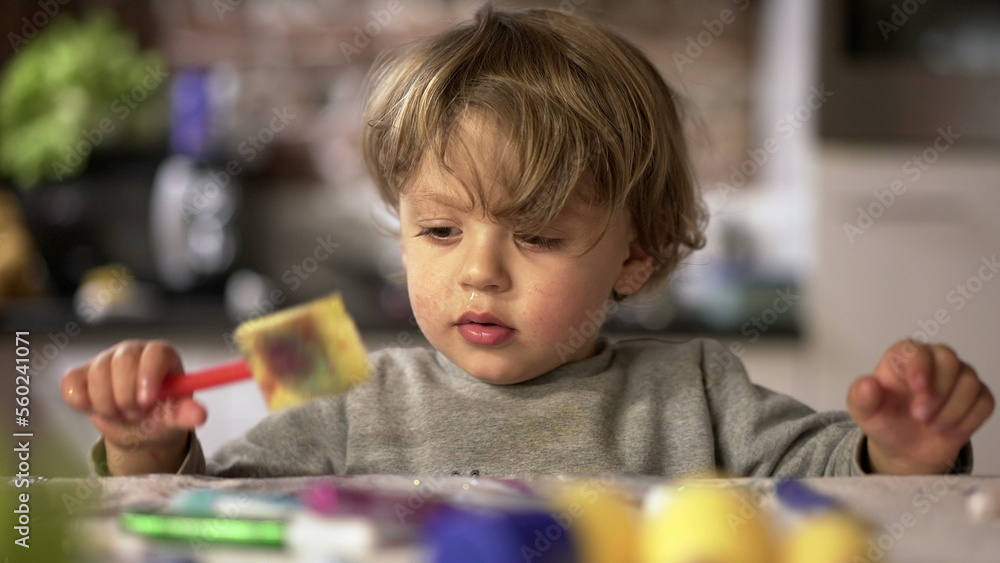 Artistic baby toddler playing with craft toys at home