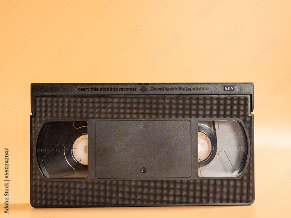 Old VHS cassettes on an orange background. Retro video cassettes.