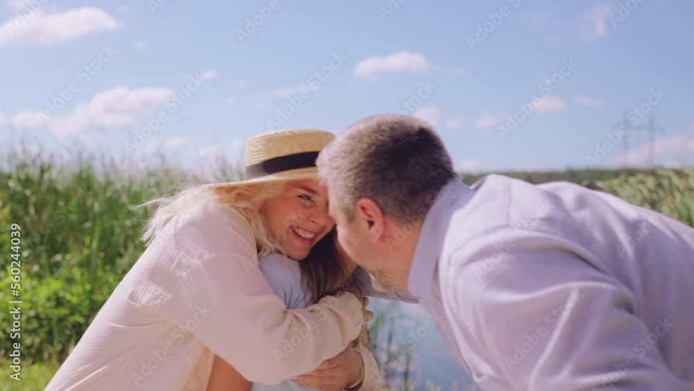 Middle-aged couple and their daughter enjoying beautiful summer day outdoors Middle-aged couple and their daughter enjoying beautiful summer day outdoors
