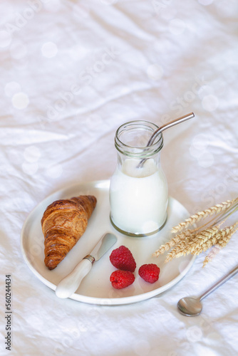 Coissant, milk and fresh berries, french breakfast on a bad photo