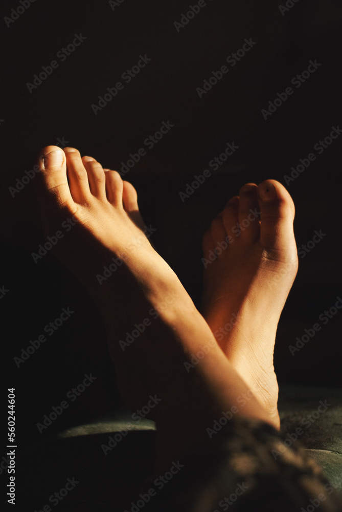 Fototapeta premium Feet of a girl in a sun light