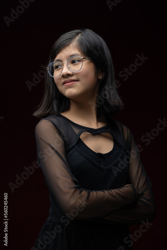 12 year old Mexican  girl portrait isolated on red background wearing glasses