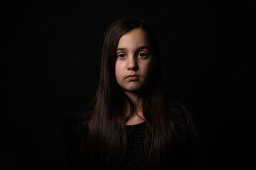 Portrait of sad little girl on black background