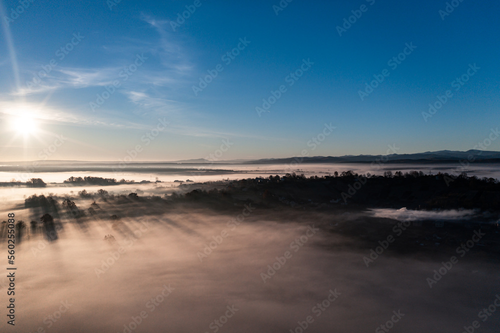 Photo from a drone over the village when the fog fell with thick clouds, a beautiful morning over the village.