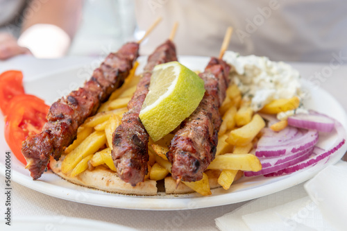 Traditional Greek food served in tavern, made from Kebab Beef Souvlaki, french fries, salad and pita bread