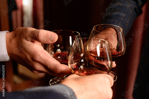 male hands holding whiskey glasses. photo