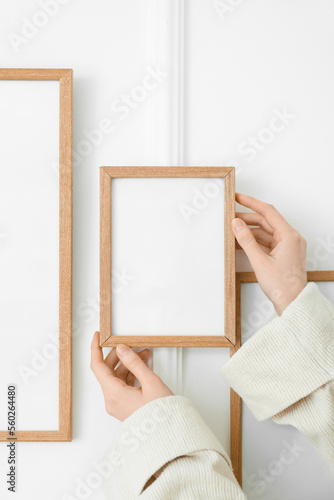 Woman hanging blank photo f...