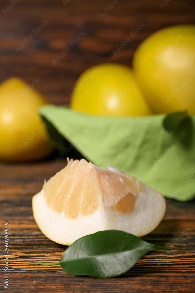 Piece of sweet pomelo fruit on wooden table, closeup Piece of sweet pomelo fruit on wooden table, closeup