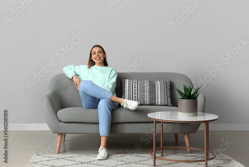 Young woman sitting on soft...