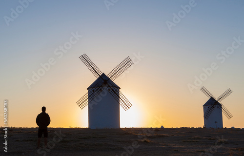 Man observing Campo de Criptana windmills, Spain photo