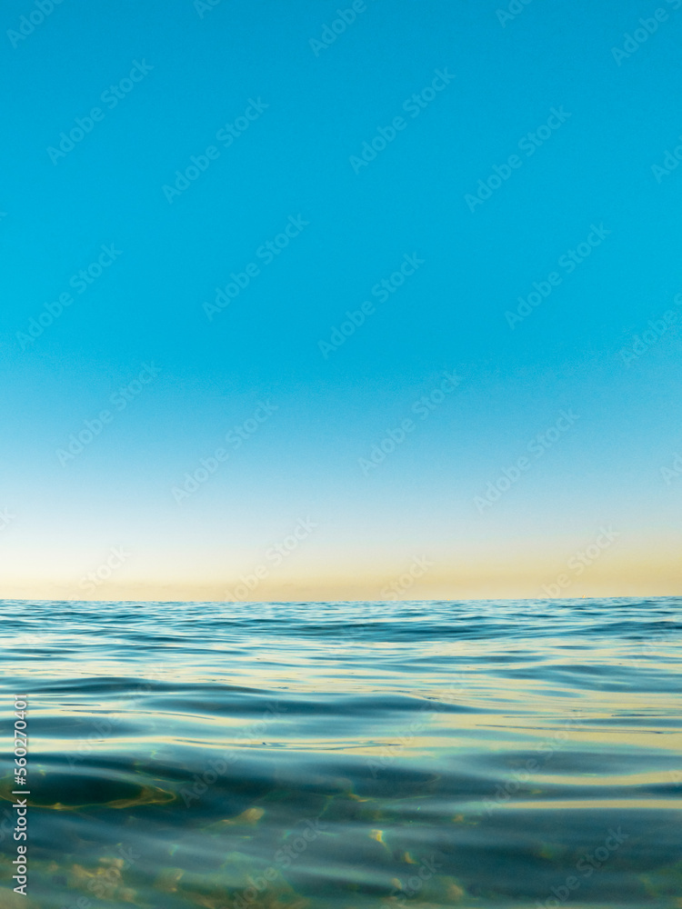ocean surface with reflection of blue sky