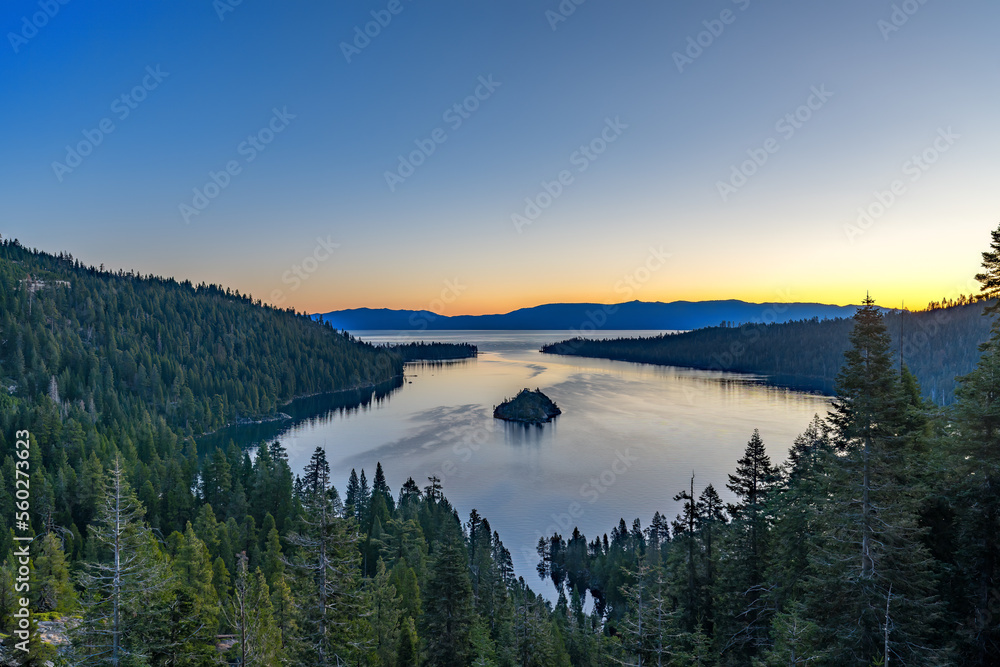 South Lake Tahoe viewed from the mountains with a body of water and small island in the middle with blue sky and room for text