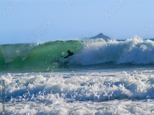 Silhouette of surfer in curl of wave