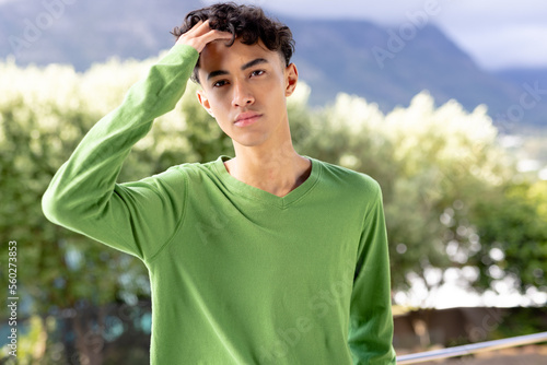 Image of biracial man in green long sleeve top with copyspace over trees in background