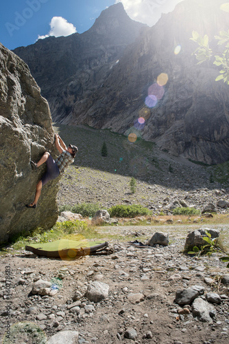 Man climbing boulder in area of Ailefroide during sunny weather, Pelvoux, Haute-Alpes, France photo