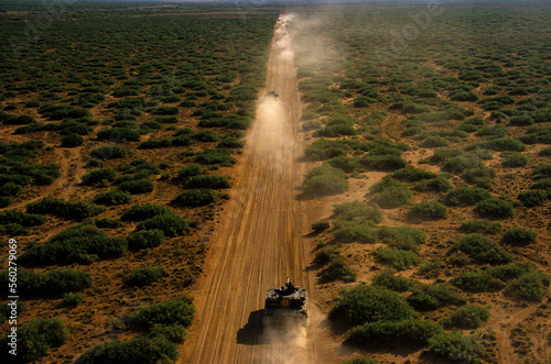 Army tanks traveling on dusty straight dirt road during training exercises in west Texas, Ft. Bliss, El Paso, Texas. photo