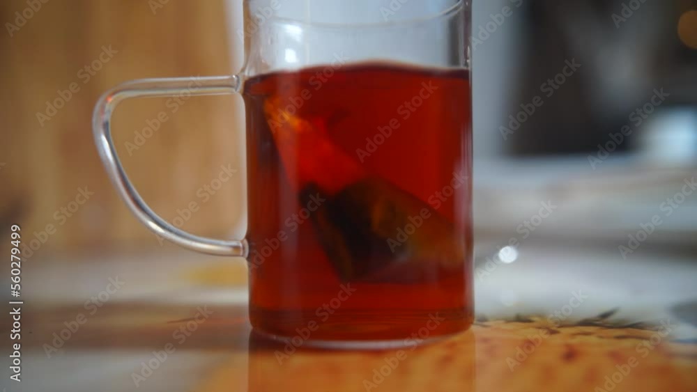 Tea bag in a glass of tea. Making morning tea. Brew black tea bags in a glass glass. Tea bag in a glass of tea. Making morning tea. Brew black tea bags in a glass glass.