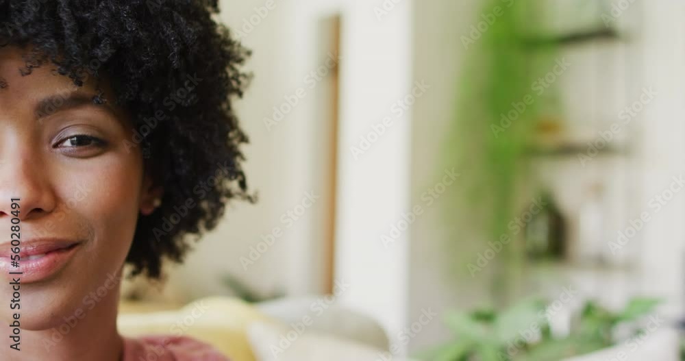 Video half face portrait of smiling biracial woman laughing at home, with copy space Video half face portrait of smiling biracial woman laughing at home, with copy space