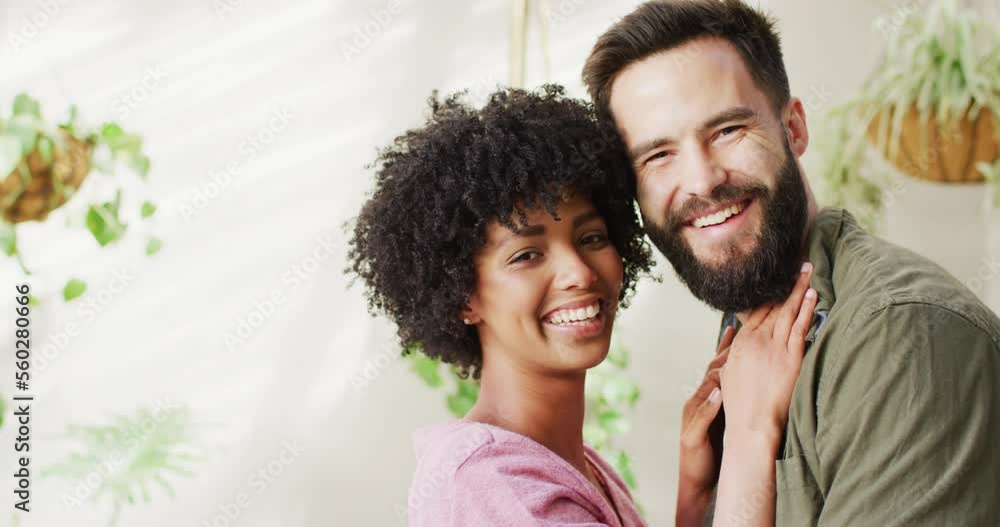 Video portrait of happy diverse couple in living room embracing and smiling, with copy space Video portrait of happy diverse couple in living room embracing and smiling, with copy space