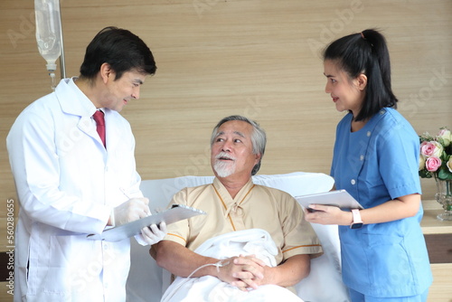friendly smiling doctor talking and explaining test result to elderly patient in hospital