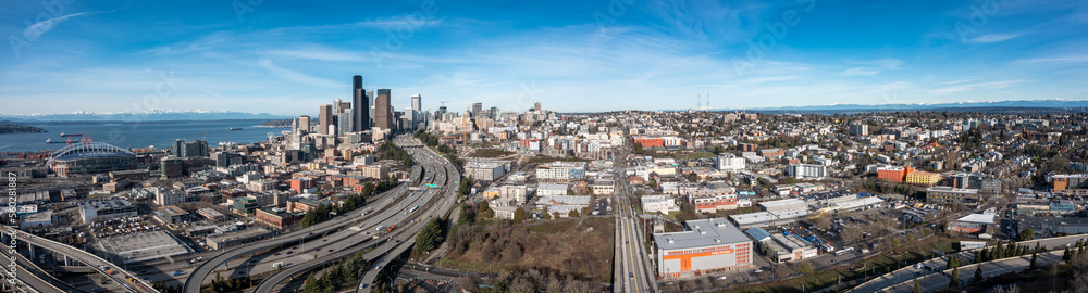 Panoramic aerial view of Seattle Downtown with Lumen Field, Highways, Capital Hill and snow covered mountains in the background