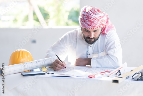 Architect concept, Architects working with blueprints in the office Business accessories (laptop, smartphone, pens, magnifier), accessories for drawing (plans, rulers) and learning on the table