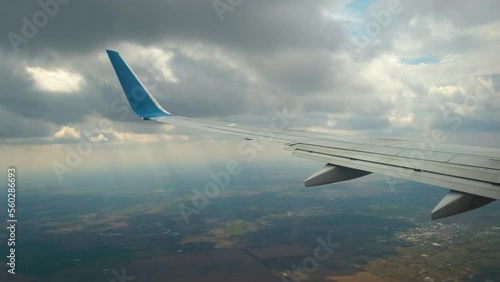View of jet airplane wing shaking from air turbulence while flying through dark storm clouds. Travel and air transportation concept