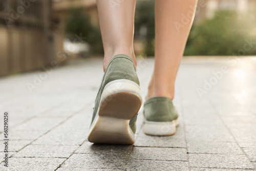 Woman in stylish loafers walking on city street, closeup