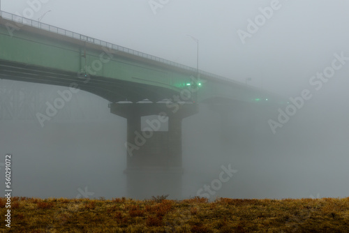 green road bridge disapears into heavy fog over the Missouri river in Kansas City