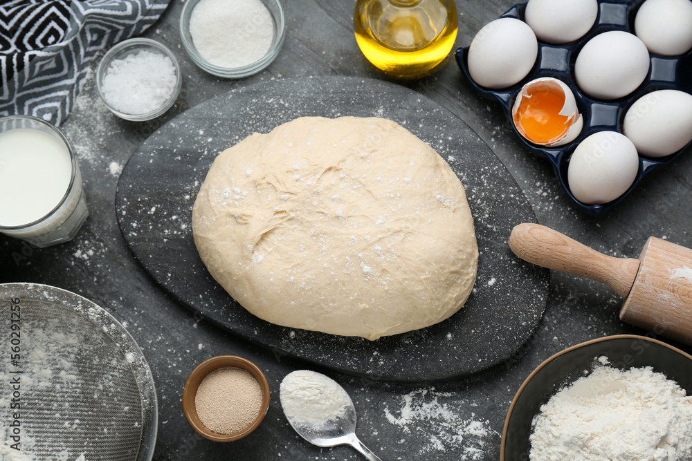 Fresh yeast dough and ingredients on black table, flat lay Fresh yeast dough and ingredients on black table, flat lay