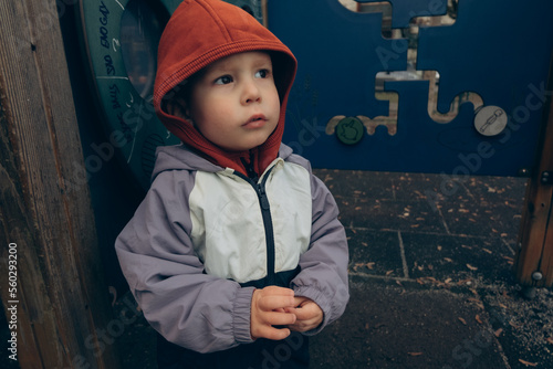 Foto portrait of a brown-eyed child in a hood on the playground