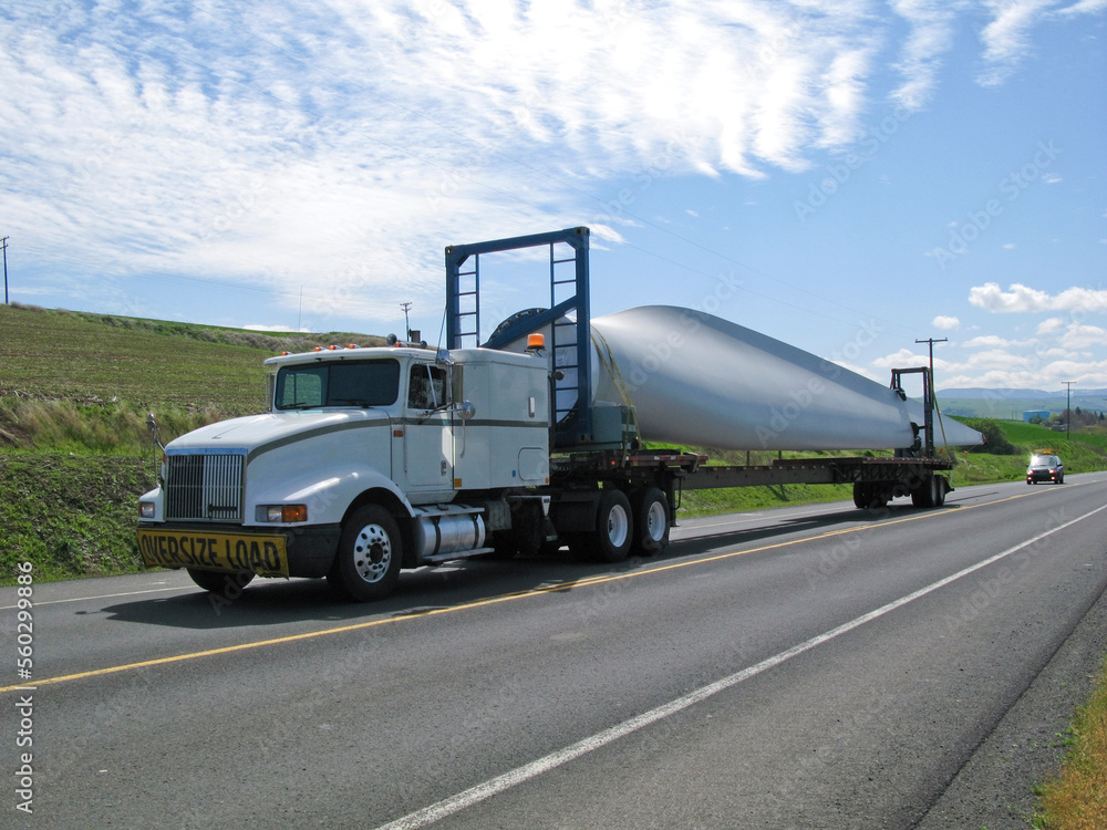 A truck carries one blade of a wind turbine to its final destination.