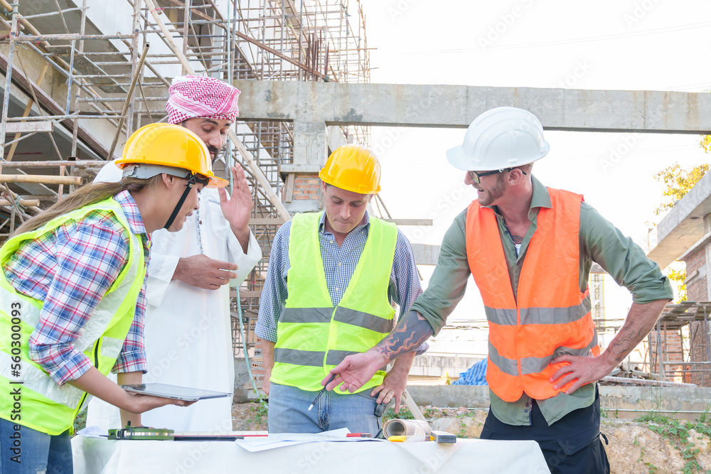 Diverse team of professionals using tablet computers on construction site. Real estate construction project. with civil engineers, architects, Arabic business investors and explorer with theodolite Diverse team of professionals using tablet computers on construction site. Real estate construction project. with civil engineers, architects, Arabic business investors and explorer with theodolite