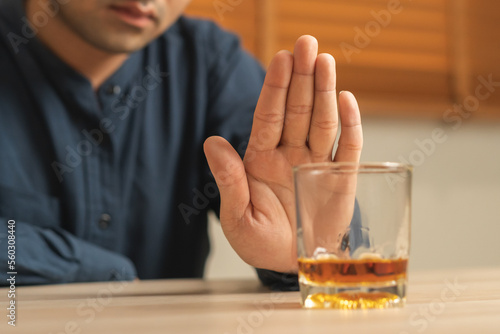 Obraz na plátně Alcoholism, depressed asian young man refuse, push out alcoholic beverage glass, drink whiskey, sitting alone at night