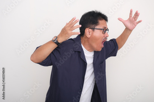 Asian man, standing in casual clothes looking frustrated and anxious